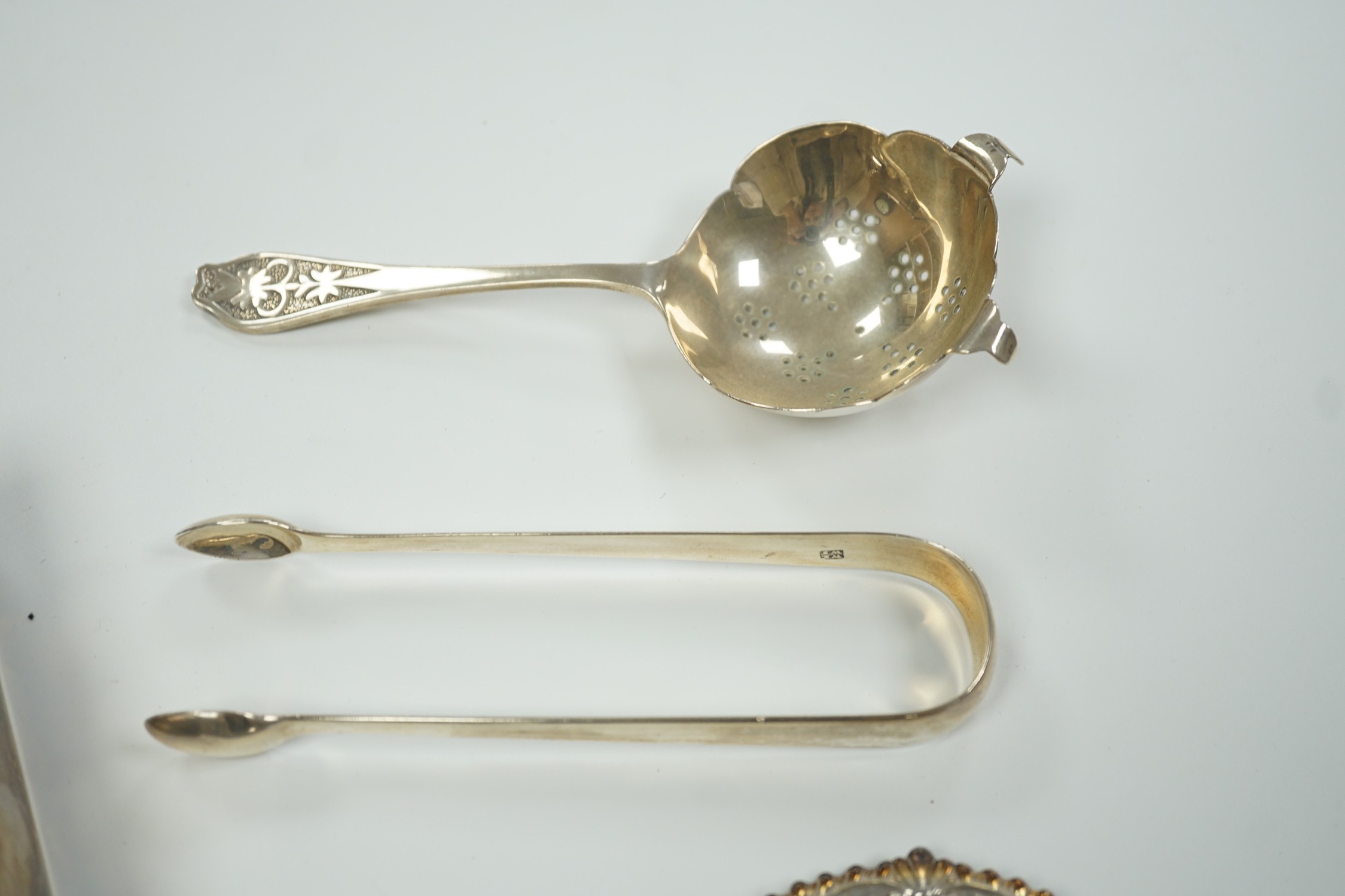 A Chinese sterling mounted cigarette box by Wai Kee, 92mm, a set of six modern silver small dishes, a silver tea strainer, par of Georgian silver sugar tongs and a modern silver mounted posy vase.